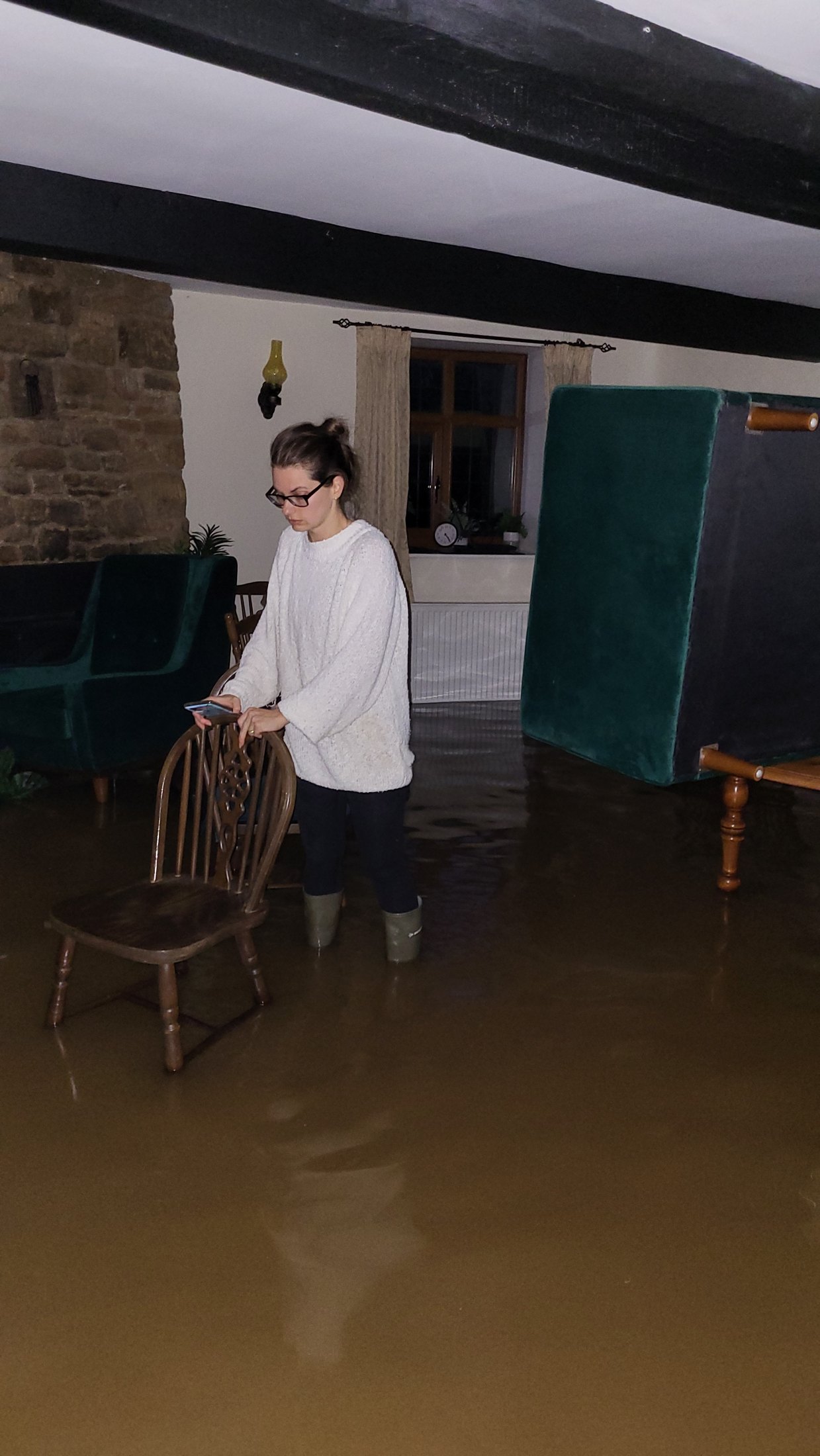 Resident standing in floodwater inside a property